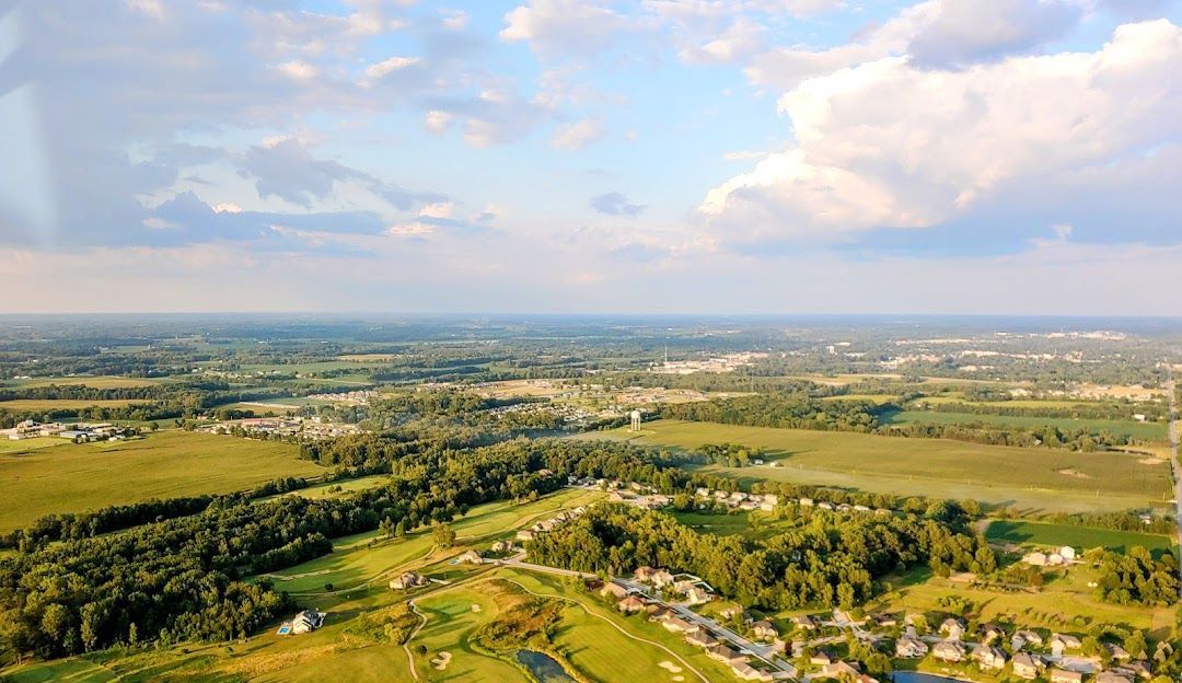 An aerial view of a lush green landscape with trees and fields.
