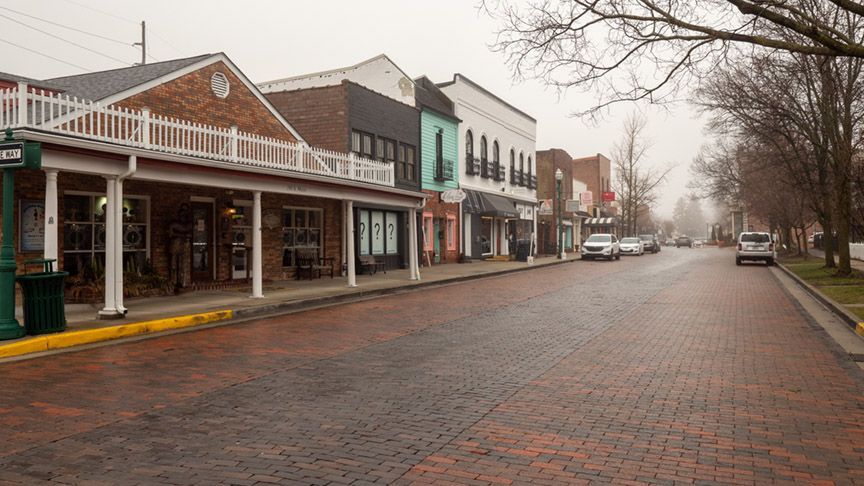 A row of buildings on a brick street in a small town.