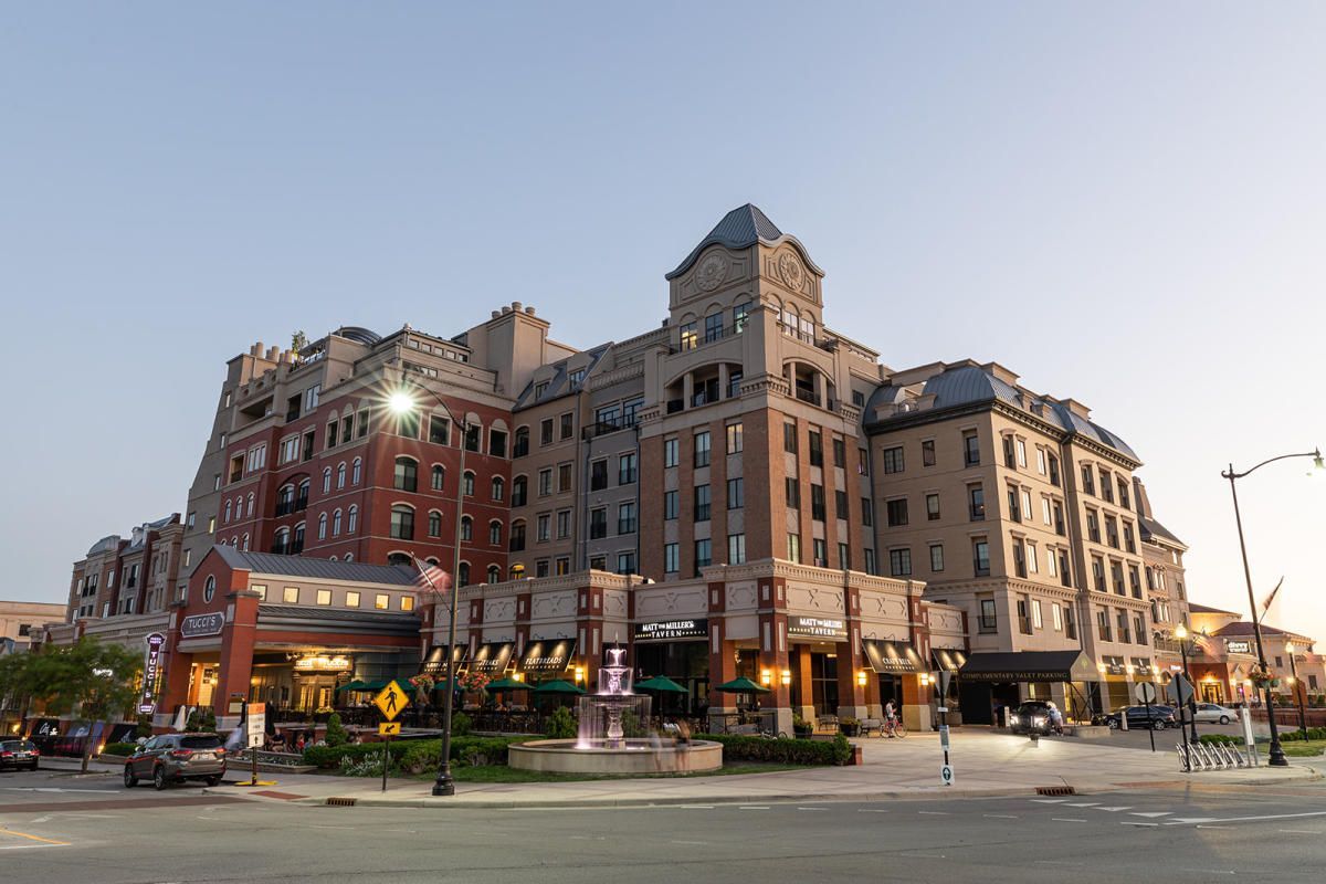 A large brick building is sitting on the corner of a city street.