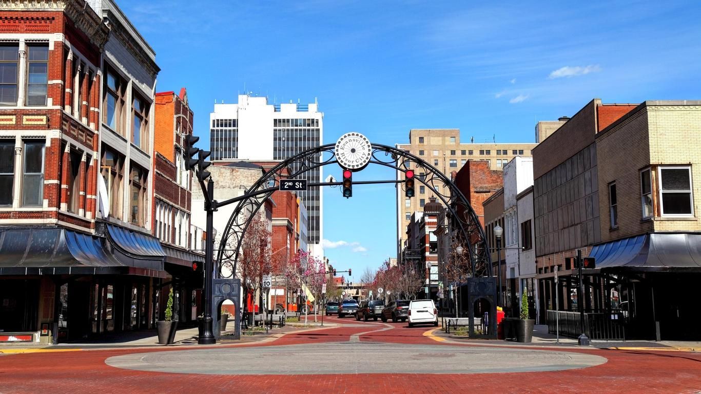 A city street with a clock in the middle of it