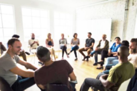 A group of people are sitting in a circle in a room.