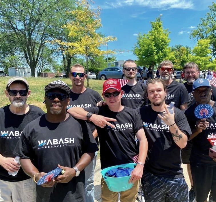 A group of men wearing wabash shirts pose for a picture