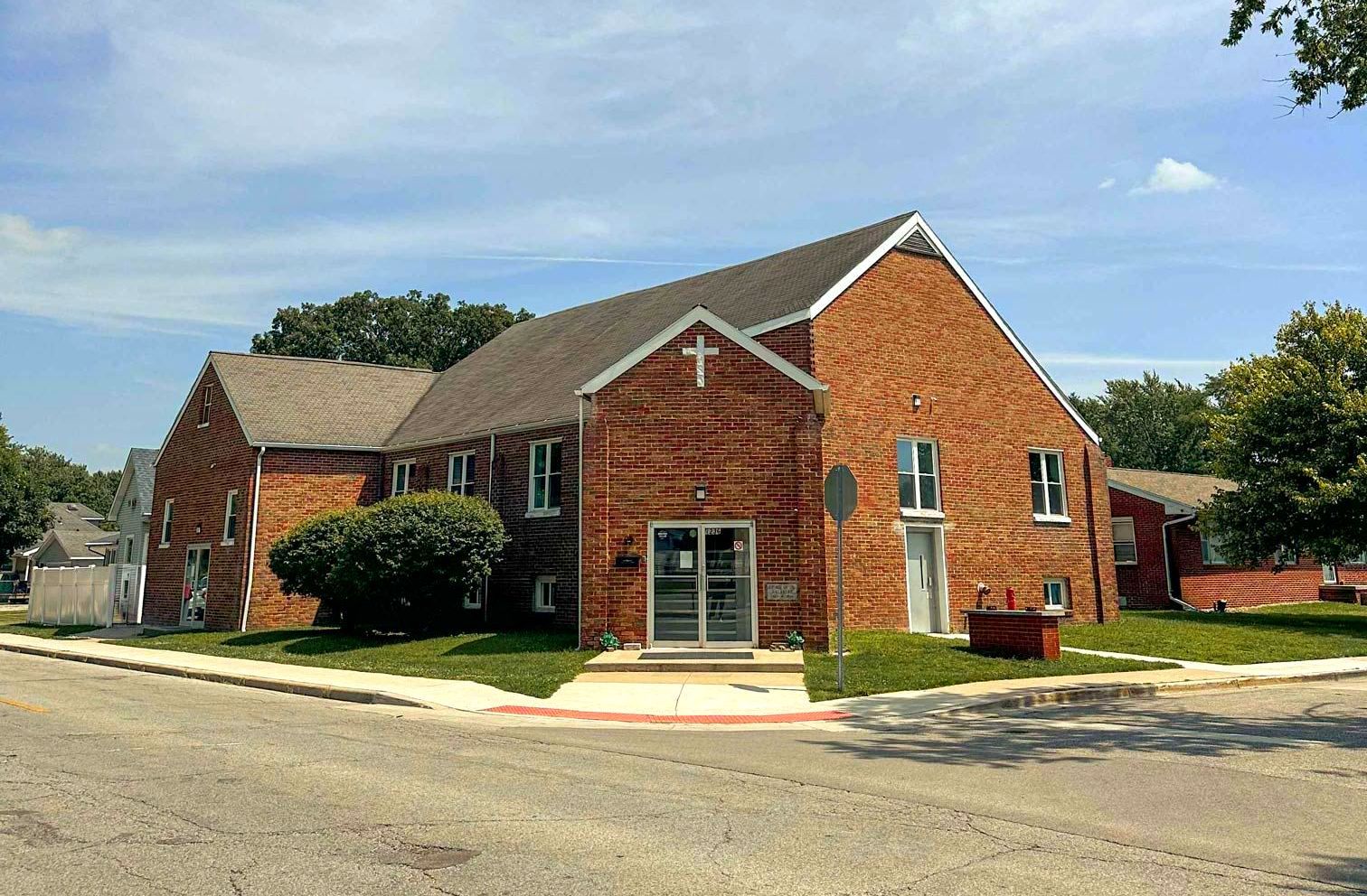 A brick building with a cross on the top of it