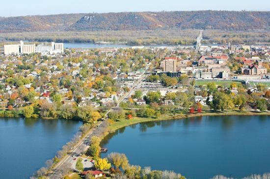 An aerial view of a city surrounded by trees and a lake.