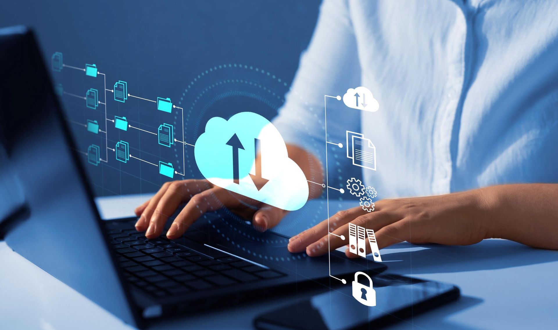 Person using laptop with cloud computing graphic overlay.