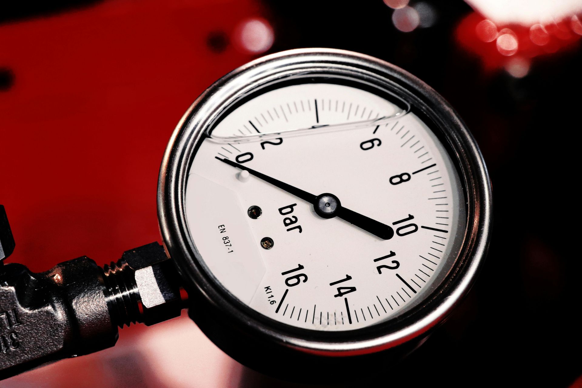 Pressure gauge showing approximately 9 bar on a red machine.