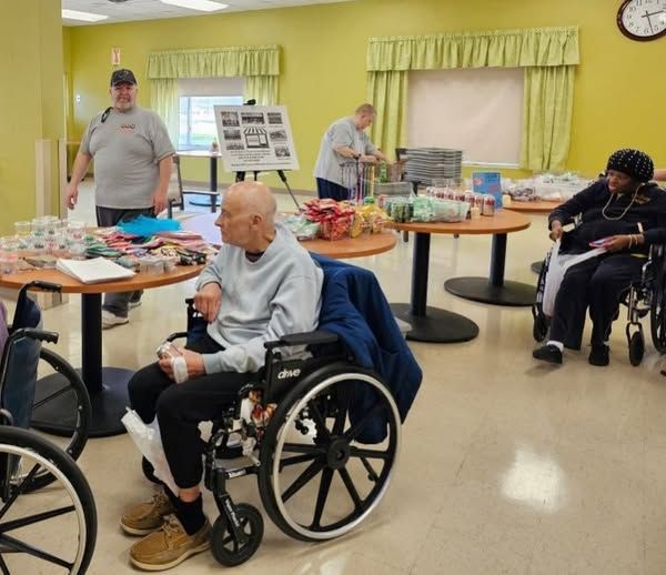 A man in a wheelchair is sitting at a table with other people.