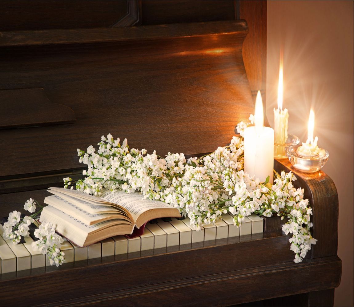 Libro aperto con fiori bianchi e candele accese su un altare di legno scuro
