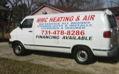 A white service van parked in a driveway, displaying 