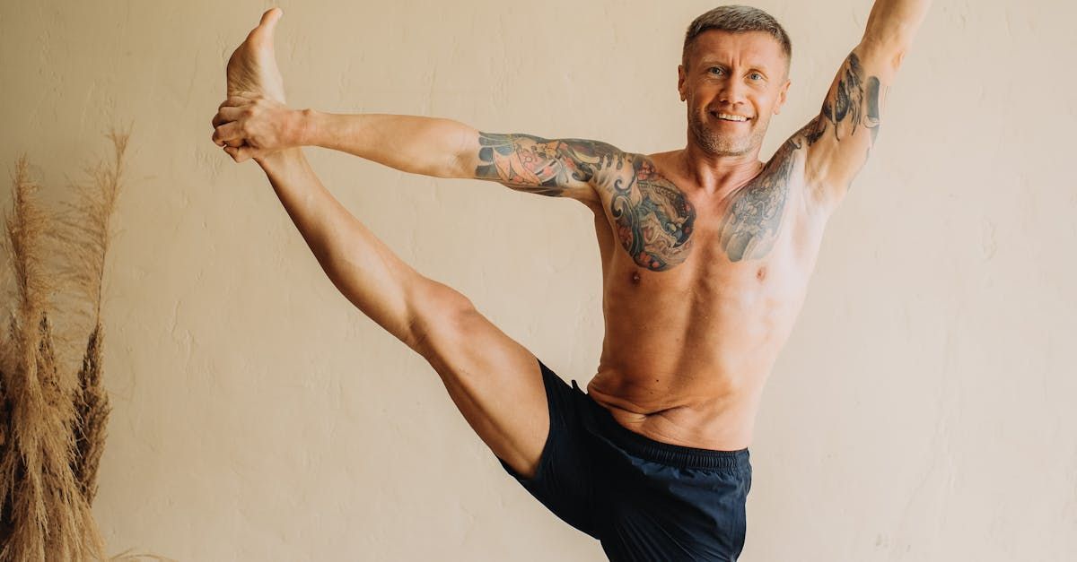 A shirtless man is doing a yoga pose with his legs in the air.
