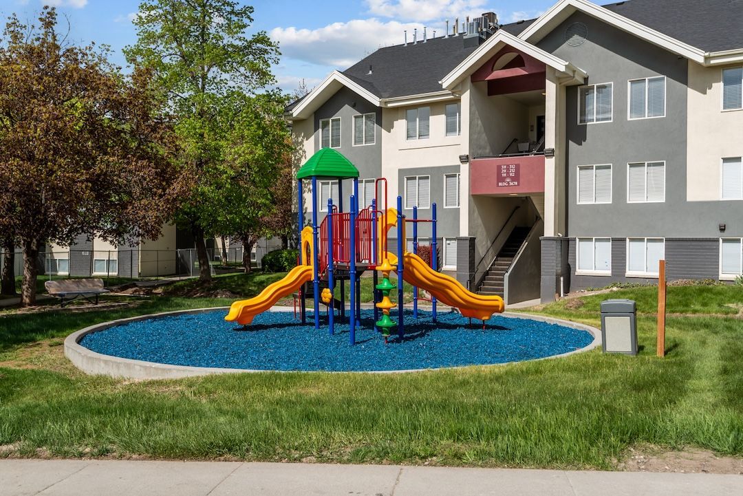 Colorful playground with slides and climbing bars in front of apartment buildings