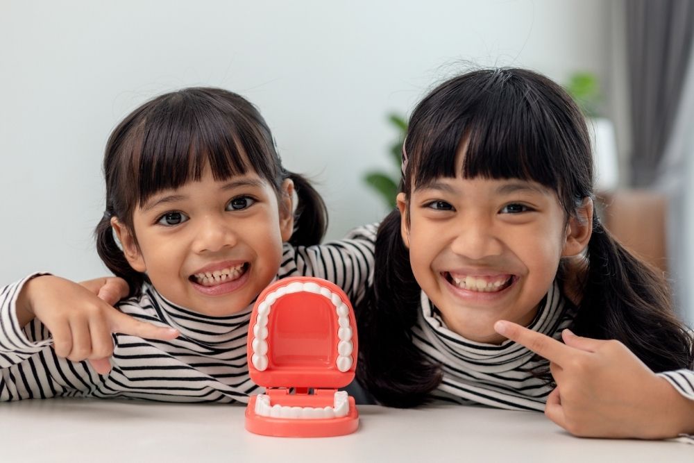 Dentist examining a smiling patient under a bright dental lamp in a clinic
