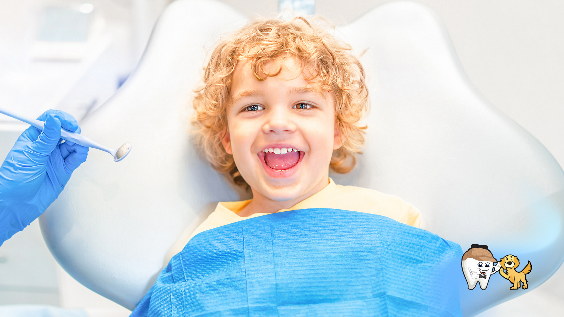 A young boy is sitting in a dental chair with his mouth open.