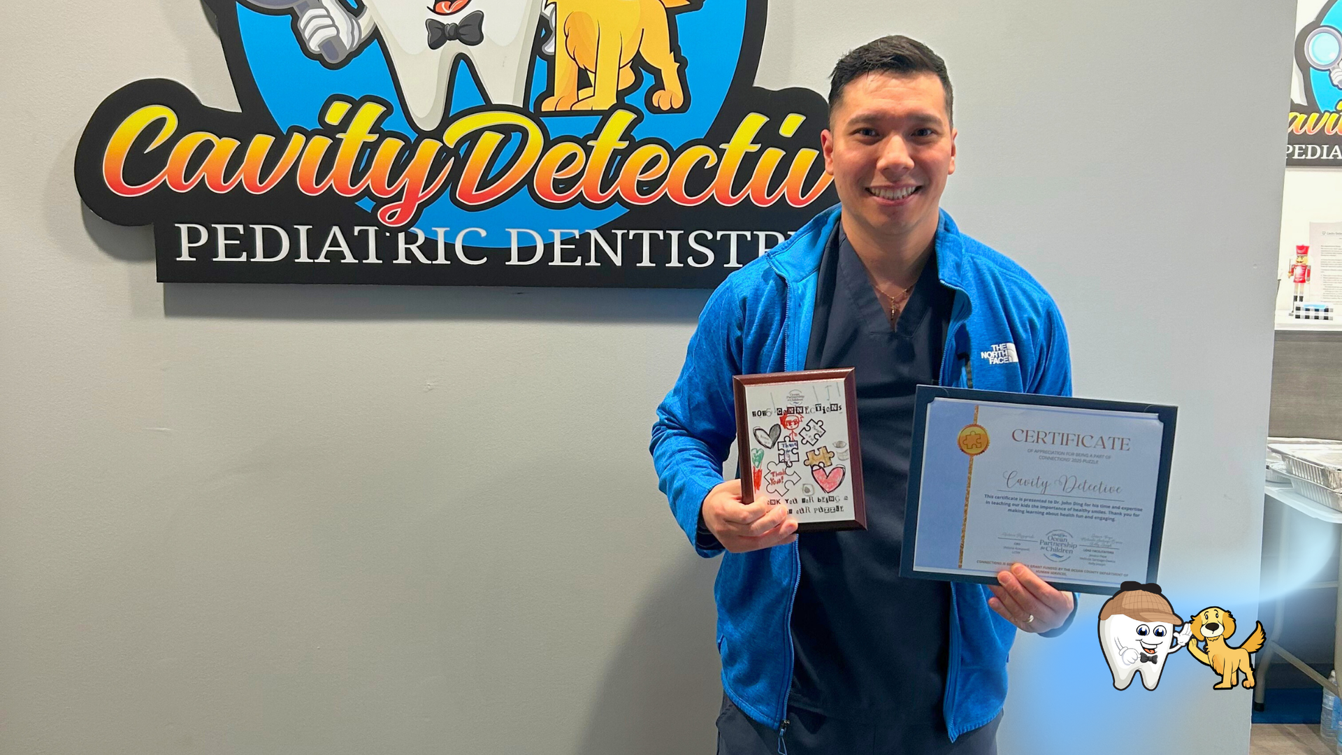 Dentist holding awards in front of 