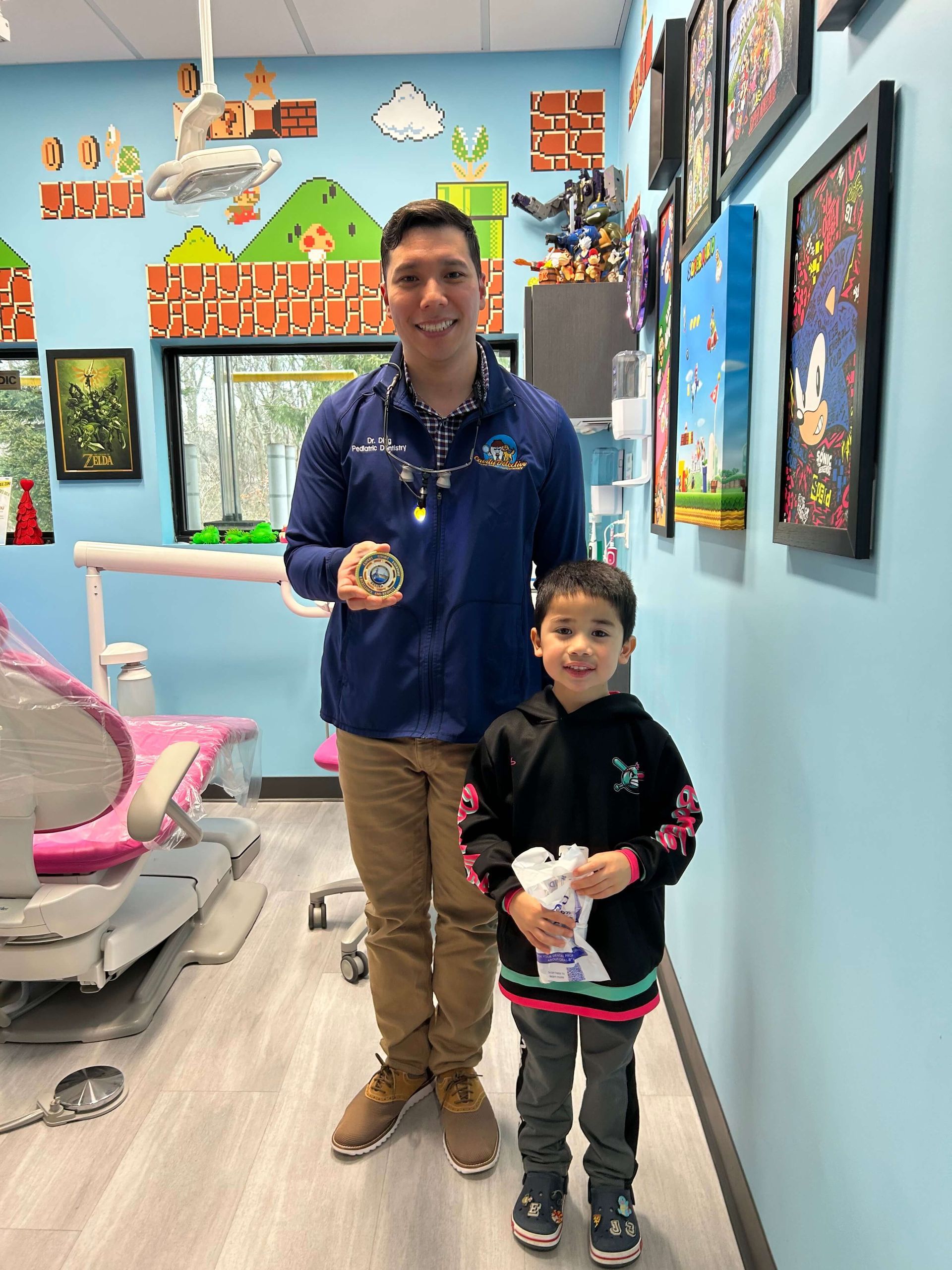 Man and child standing in a colorful art studio, each holding a decorated craft item.