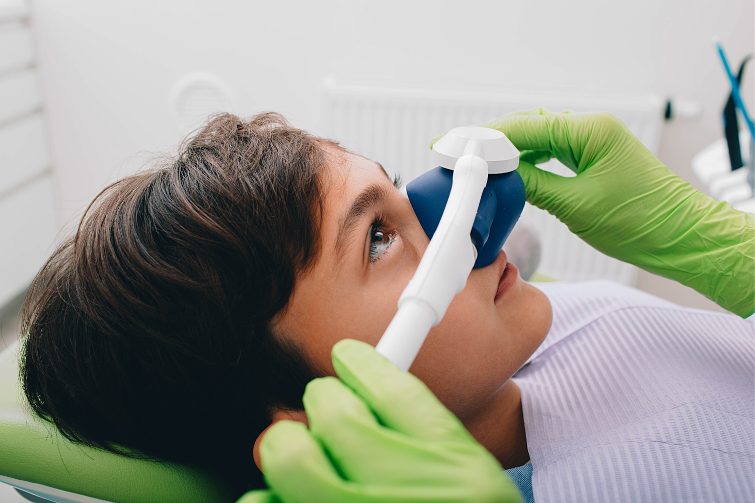 Dentist adjusting a woman’s teeth with pink gloves during a dental procedure