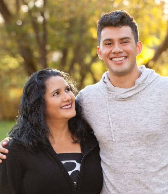 A man and a woman are posing for a picture together and smiling.
