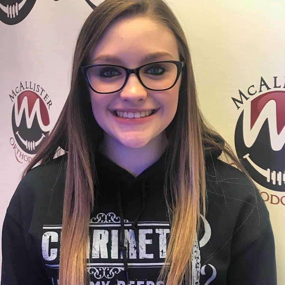 A woman wearing glasses and a sweatshirt that says cabinet
