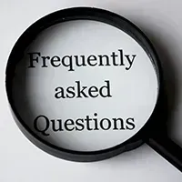 faqs Magnifying glass over the words “Frequently asked Questions” on a white background