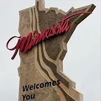White Bear Lake, Minnesota Minnesota state welcome sign with red script and “Welcomes You” text