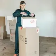 service Person loading boxes onto a hand truck in a sparse room