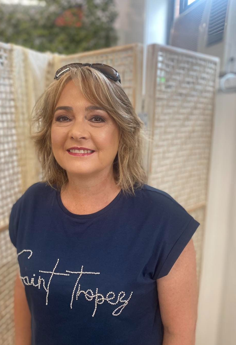 Woman With Short Dark Hair Smiles, Wearing Beige Sweater — Penelope's Beauty in Raymond Terrace, NSW