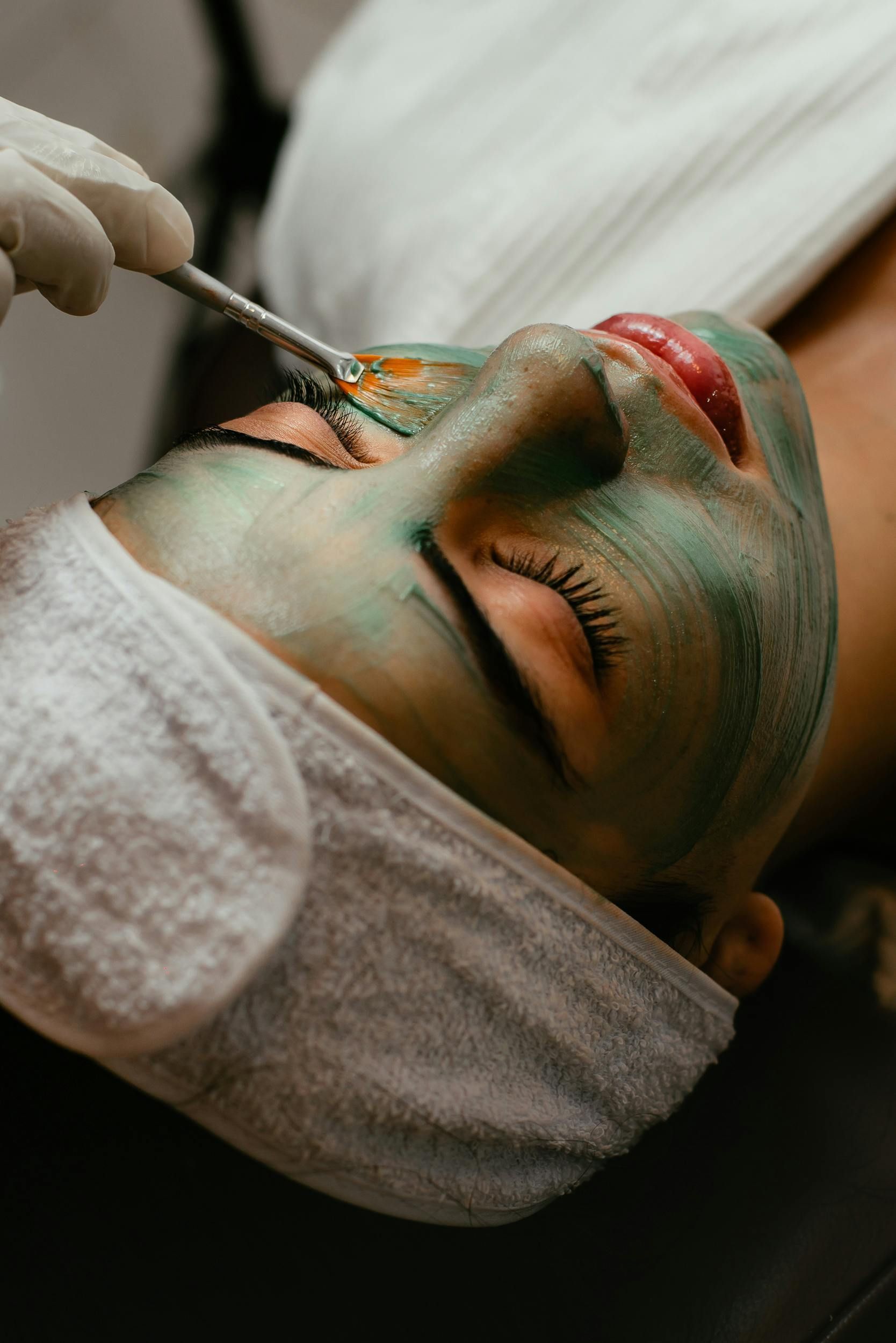 Person Receiving Facial Treatment, With Face Mask Being Applied — Penelope's Beauty in Newcastle, NSW