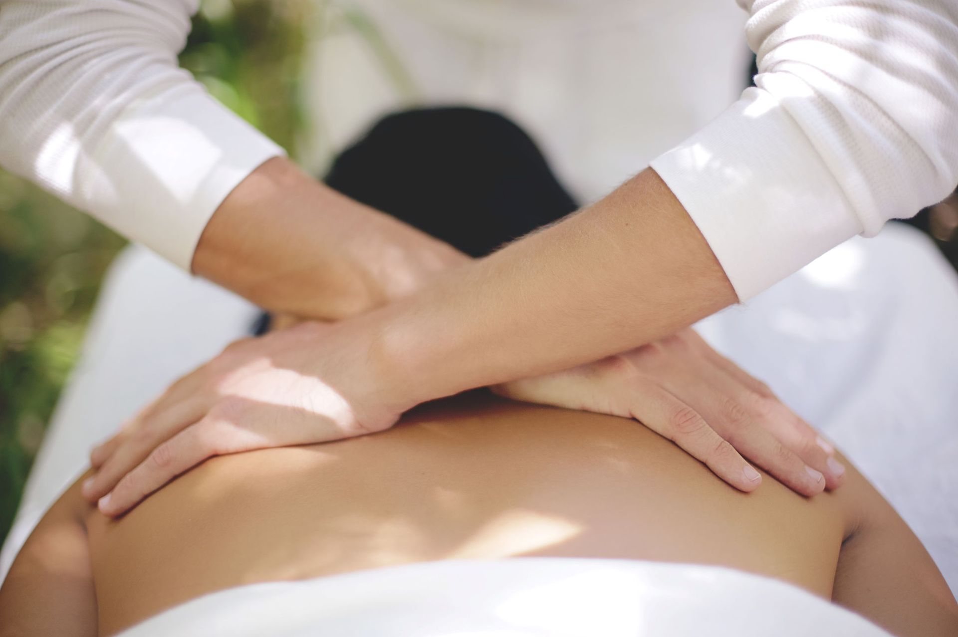 A man is giving a woman a massage on her back.