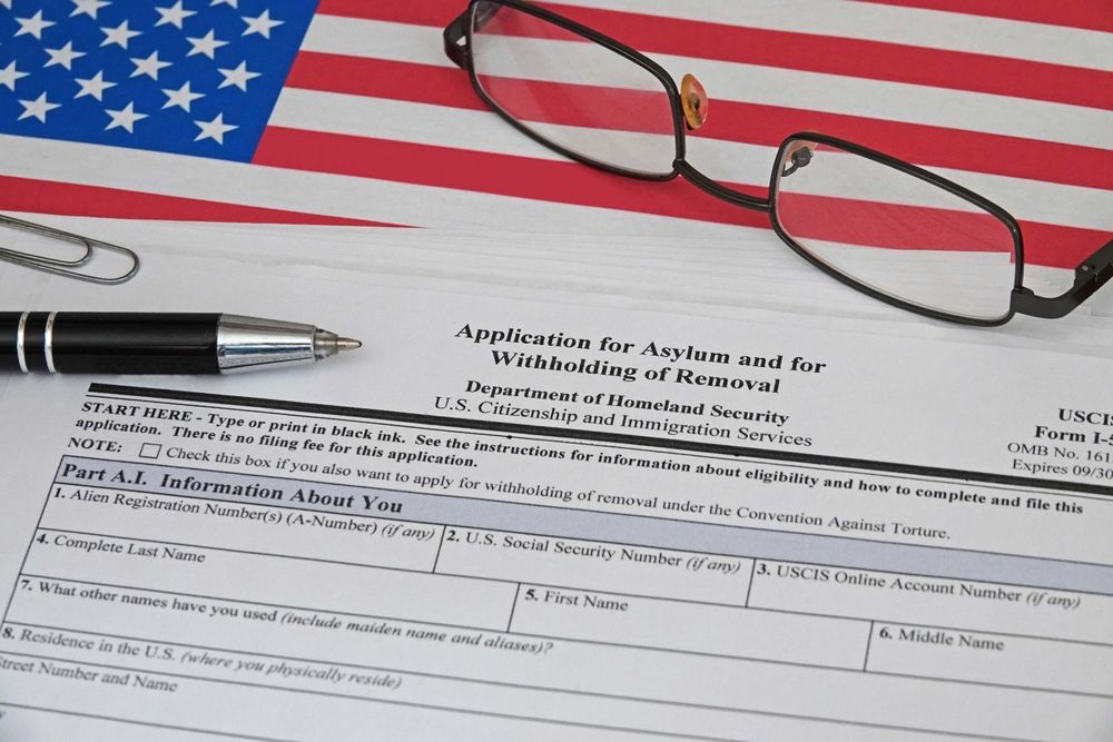 U.S. flag, eyeglasses, pen, and Social Security application form on a desk