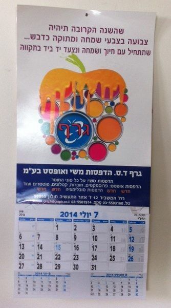 לוח שנה שולחני עם כריכת ספירלה, מציג תמונת נוף של מפל מים רחב הנשפך לבריכה טבעית מוקפת עצים. בתחתית העמוד מופיעה שורת תאריכים אופקית.