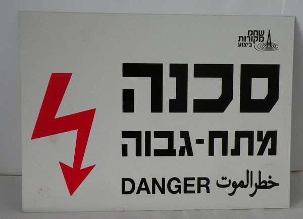 שלט אזהרה בטיחותי של חברת מקורות המציין סכנת מתח גבוה בצירוף סמל ברק אדום ובולט, המייצג ייצור שלטי בטיחות ועבודה המופקים לעיתים קרובות במקביל לפרויקטים של הדפסת קטלוג בחולון.
