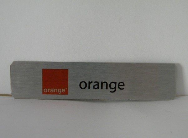הדפסת לוגו חברת אורנג' (Orange) בכתום ושחור על גבי לוחית מתכת מוכספת בסובלימציה, המציגה פתרונות שילוט ומיתוג עמידים המיוצרים באמצעות דפוס דיגיטלי בחולון.