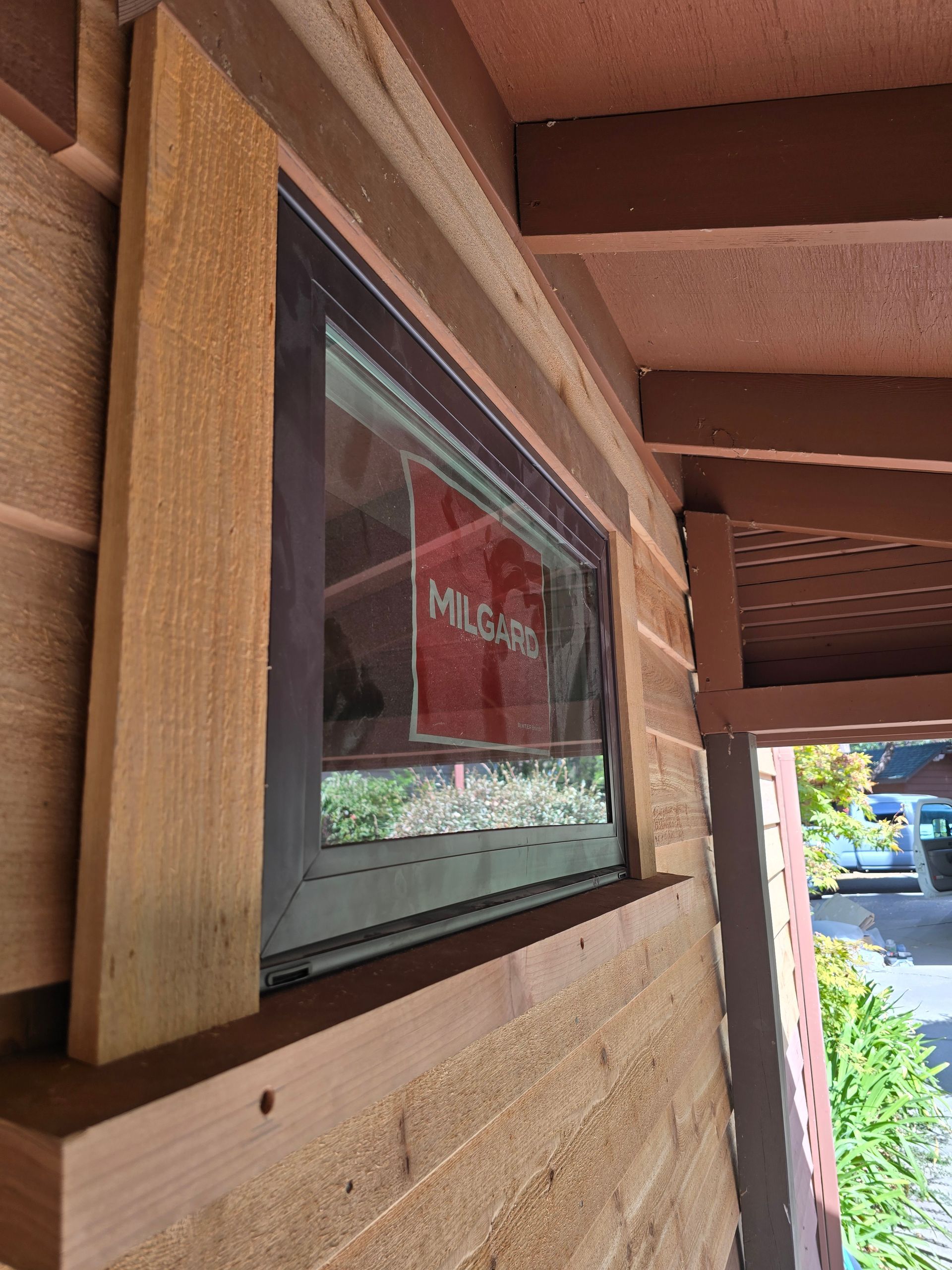 New Milgard window installed in cedar siding under a covered porch
