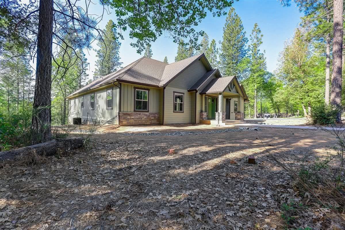 Finished single-story home with lap siding, stone wainscot and new windows on a wooded lot