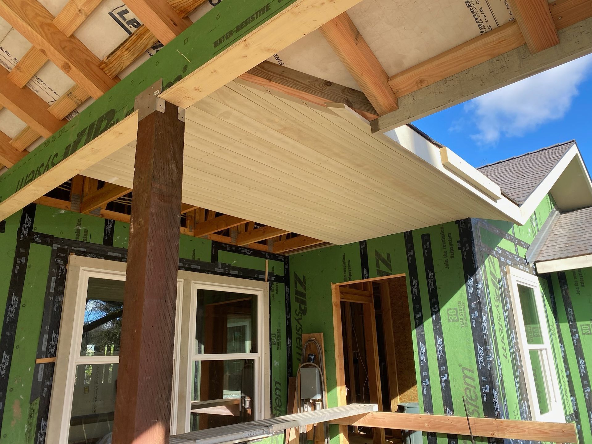 New porch soffit and beams over ZIP sheathing and new windows, before siding