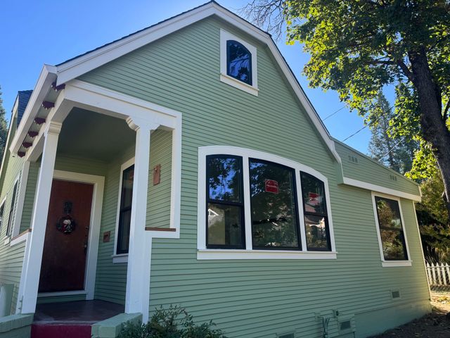 Home with green lap siding, white trim and new windows