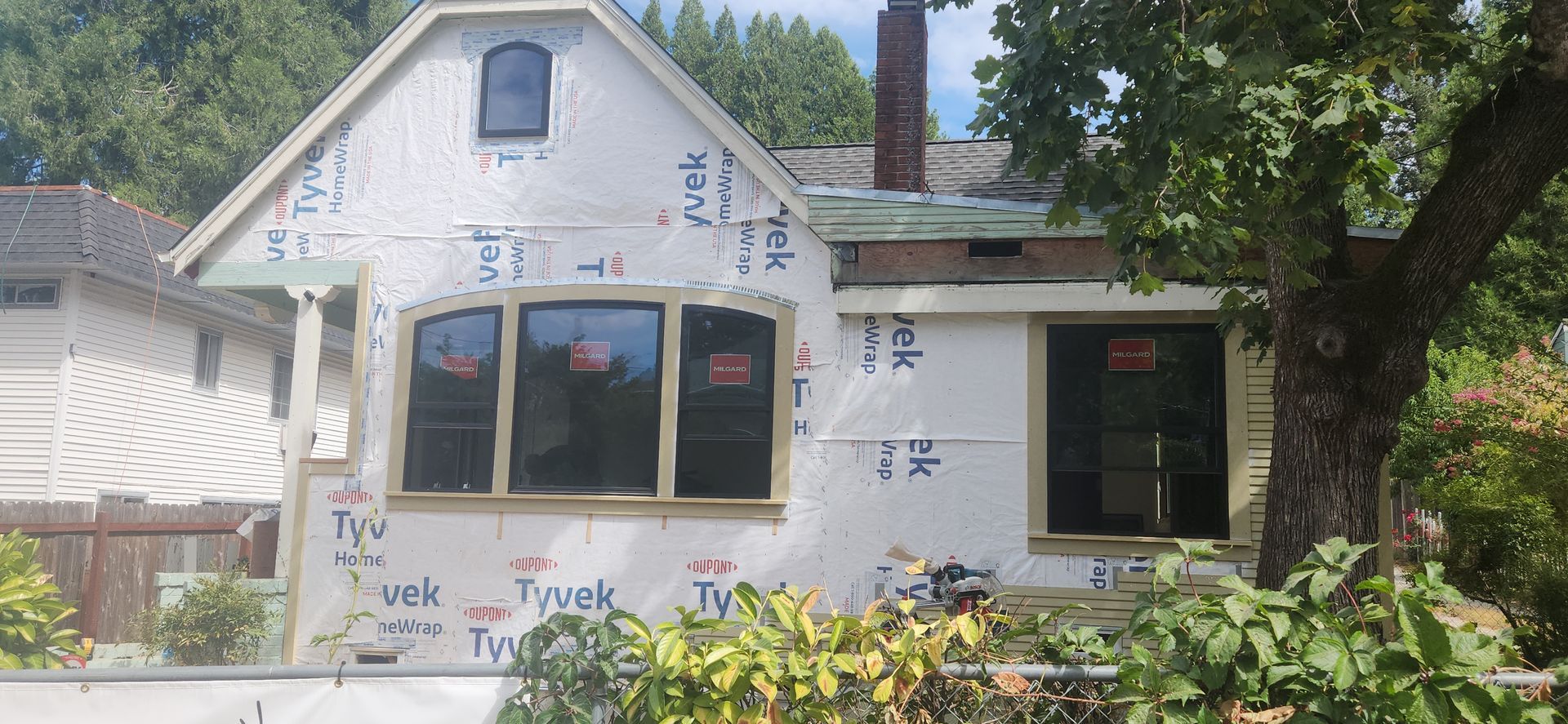 New windows installed over housewrap on an older home before the siding goes on