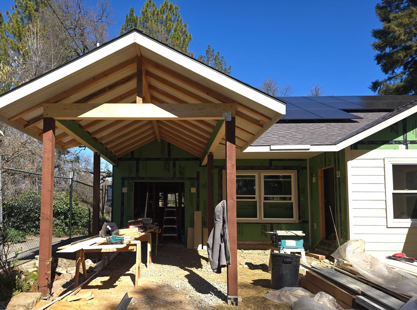 Home addition with a covered porch and exposed wood-beam ceiling on a craftsman home