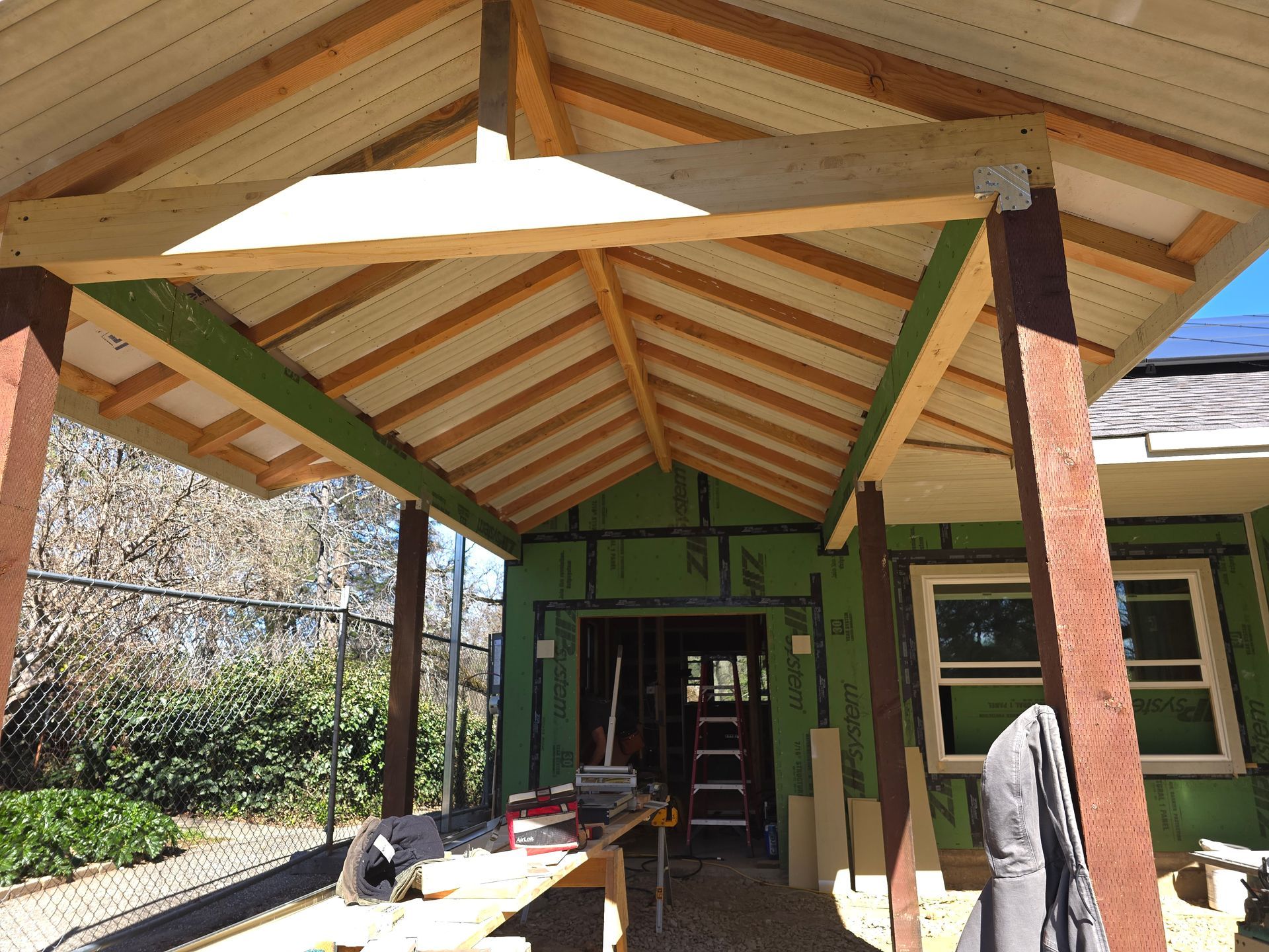 Green Bee Construction crew building a new timber-frame porch and trim on a solar-equipped foothills