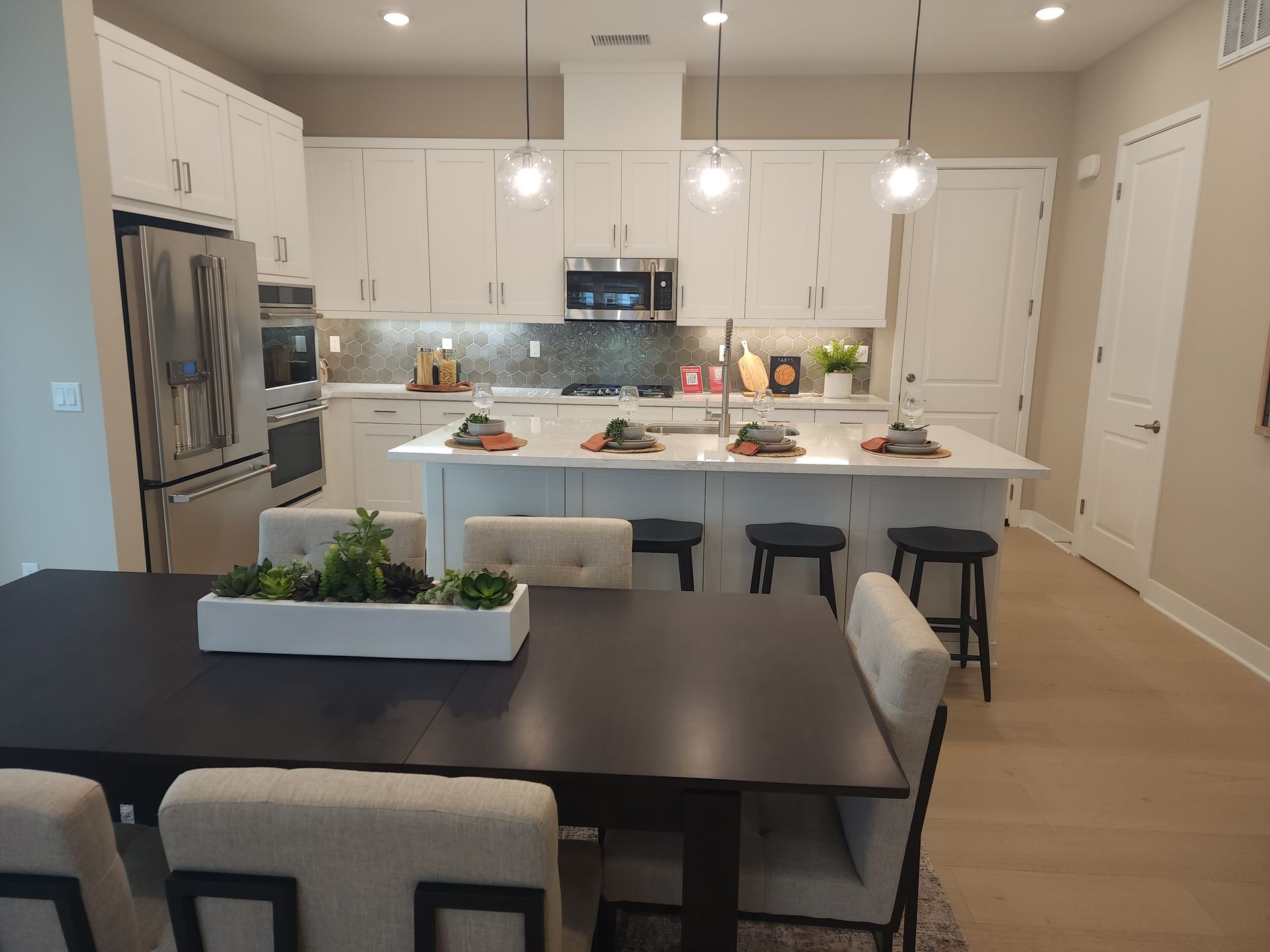 Kitchen with white cabinets, a center island, and bar seating