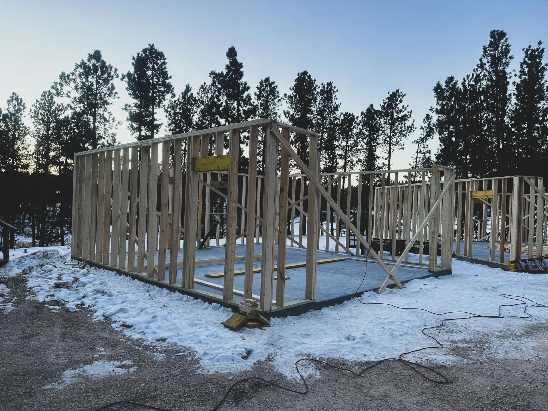 Wood-framed home under construction in a snowy setting