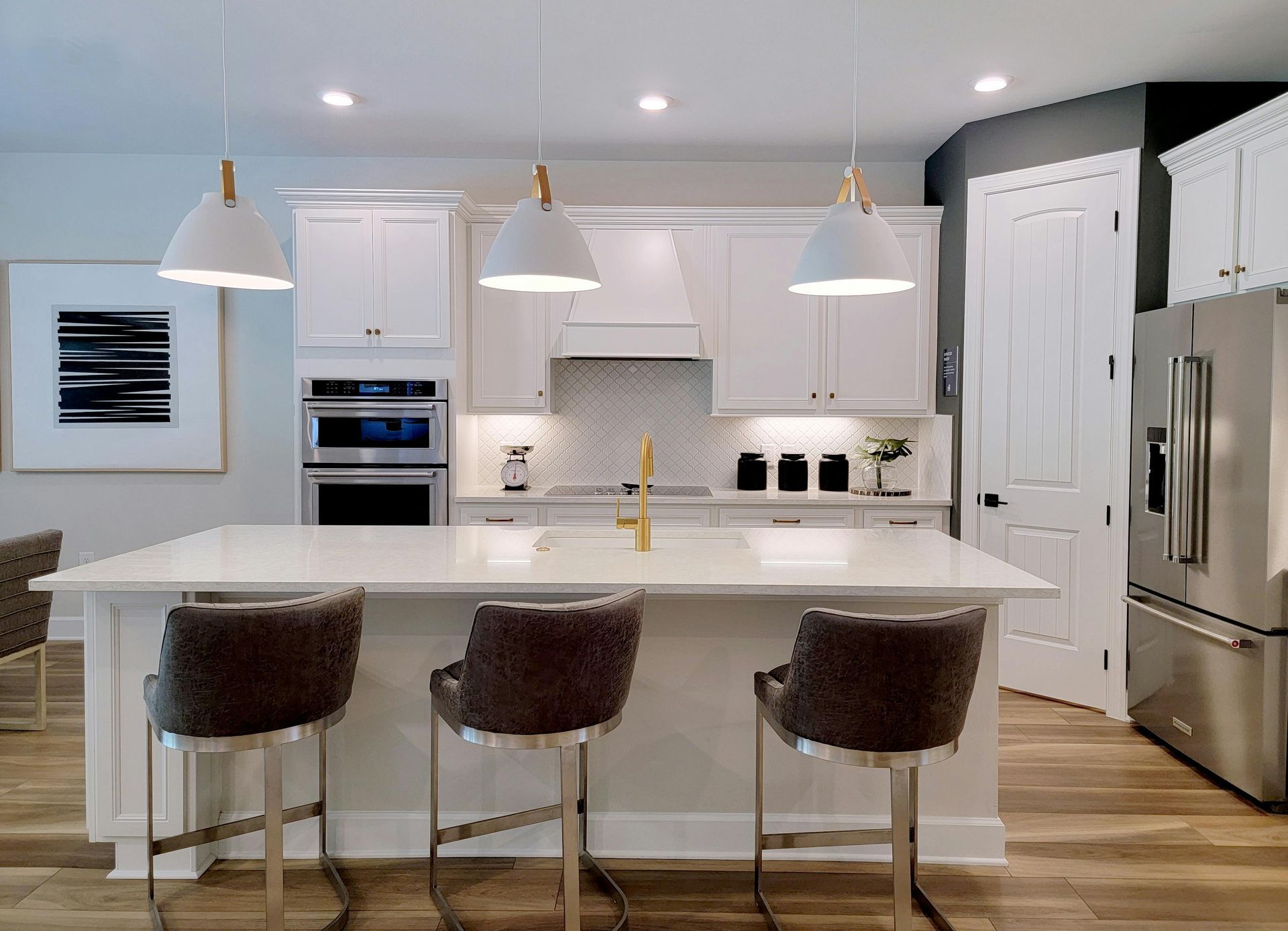 Finished kitchen, quartz island, white cabinetry, pendant lighting