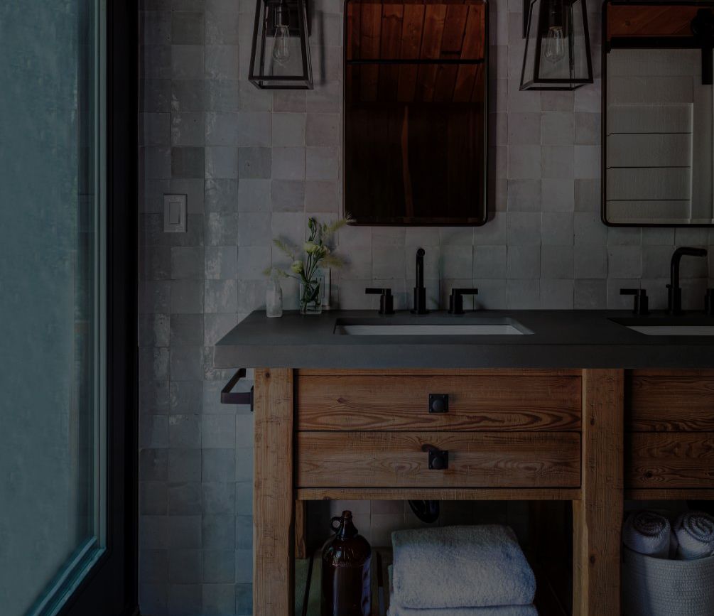 A bathroom with two sinks and a mirror on the cover of a building and remodeling guide.