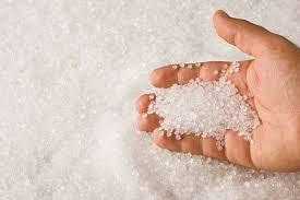 A person is holding a pile of plastic granules in their hand.