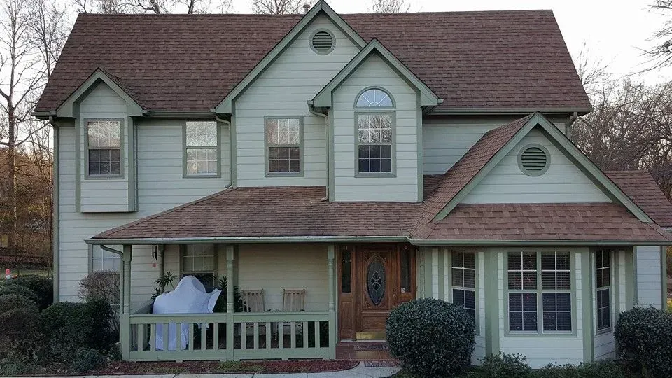 House exterior during roof construction. A ladder, scaffolding, and materials are present.