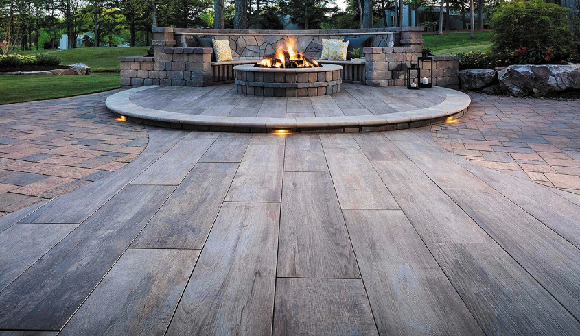 Outdoor living space with gray furniture, wooden accents, and a view into a room.