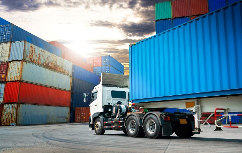 A Semi Truck is Driving Through a Warehouse Filled With Shipping Containers — Go Pack Yourself in Perth, WA