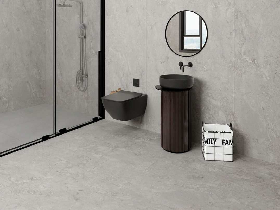 Moderno bagno grigio con doccia, WC, lavandino e specchio rotondo.