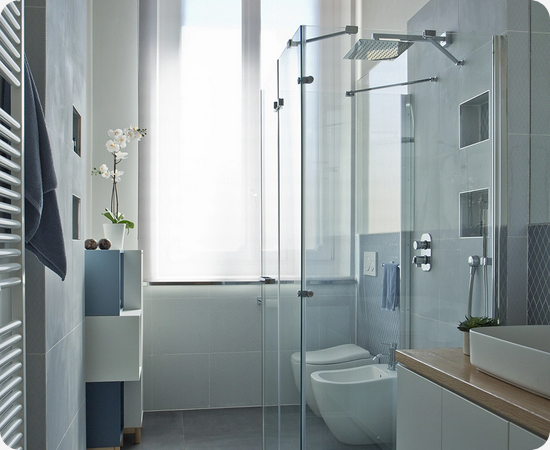 Ampio bagno moderno con pareti in marmo verde, doccia in vetro e tappeto viola.