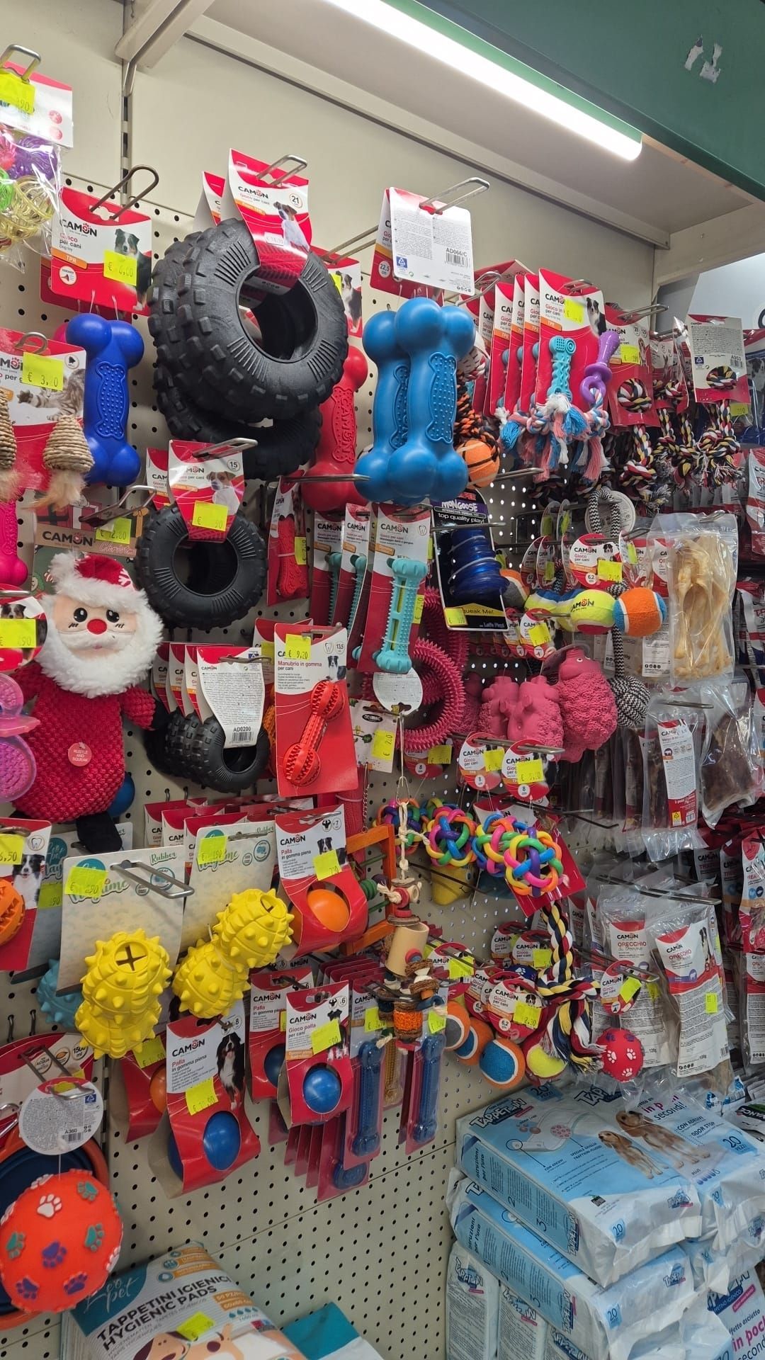Esposizione a parete di vari giocattoli colorati per cani in un negozio.